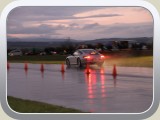 Ein Porsche fegt am Start und Ziel vorbei.